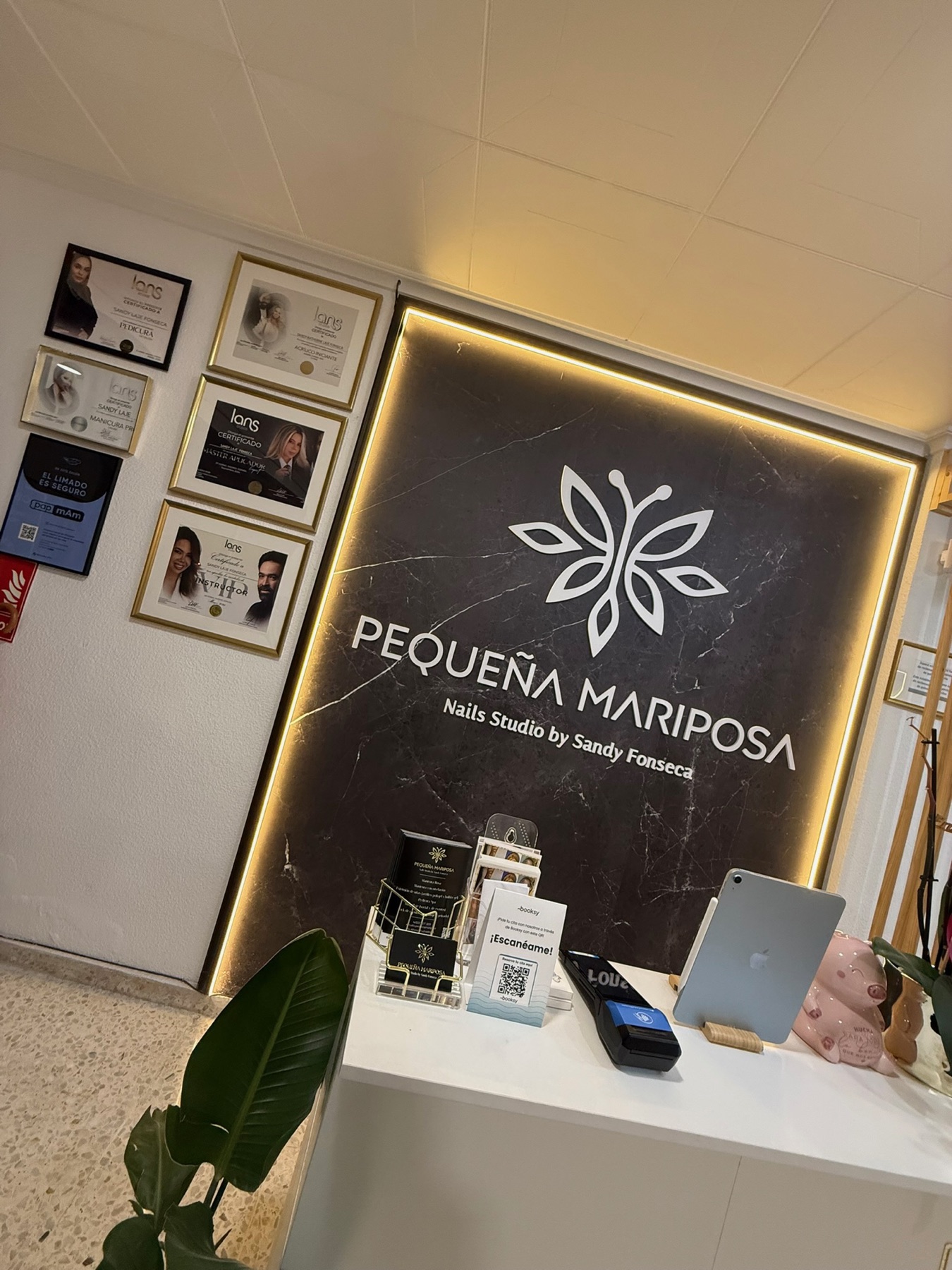 Entrada del estudio, con los diplomas de formación colgados junto al logo