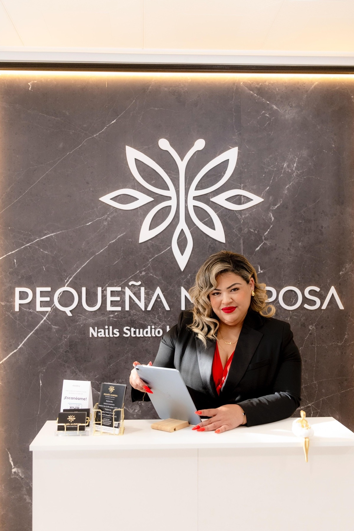Sandy Fonseca en la recepción del estudio, bajo el logo de Pequeña Mariposa